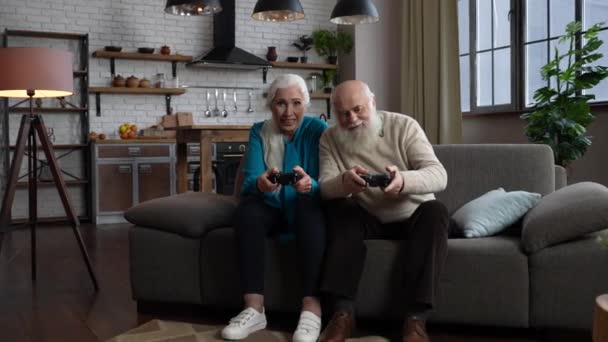 Vidám idősek videojátékoznak idebent — Stock videók