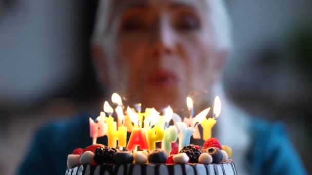 Bonne vieille dame soufflant des bougies sur le gâteau d'anniversaire — Video