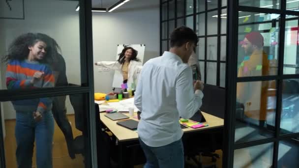 Happy colleagues dancing around table in office — Stock videók