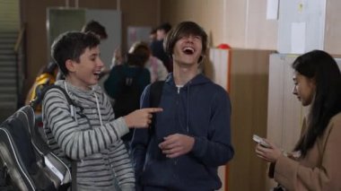 Okuldaki Asyalı kızla alay eden iki okul çocuğu.