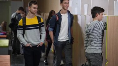 Sınıf arkadaşları okul çocuğuna zorbalık yapıyor. Dolabın yanında duruyor.