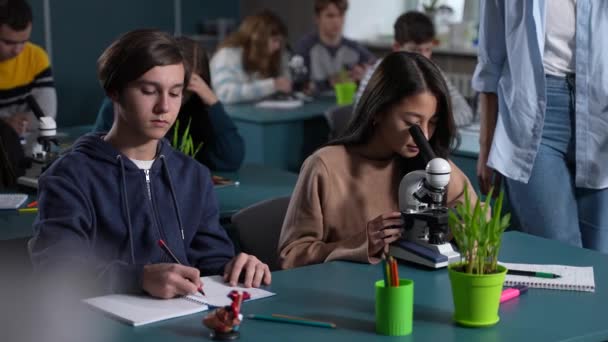 Diversos estudantes adolescentes que trabalham em aula de biologia — Vídeo de Stock