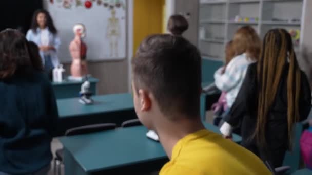 Studenți seniori multirasiali care părăsesc clasa de biologie — Videoclip de stoc