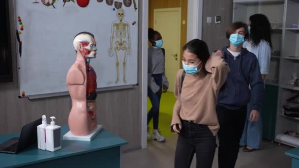 Adolescente colegas de classe em máscaras faciais entrando em sala de aula — Vídeo de Stock