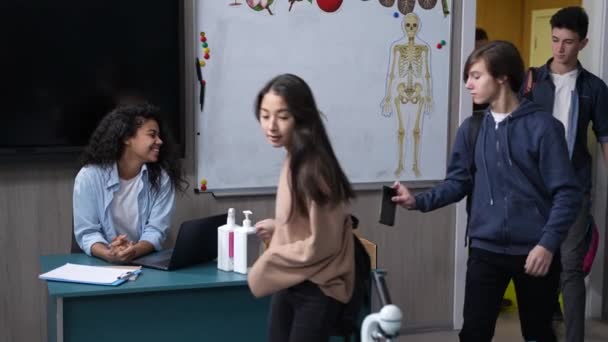 Adolescentes alunos deixando telefones entrando em sala de aula — Vídeo de Stock