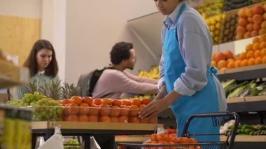 Kadın mağaza çalışanları ve süpermarkette alışveriş yapanlar.