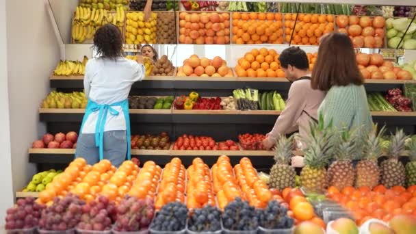 Různí kupující vybírají zeleninu v obchodě
