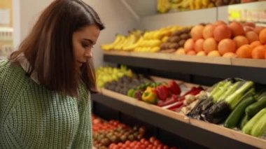 Markette alışveriş arabalı genç bir kadın.