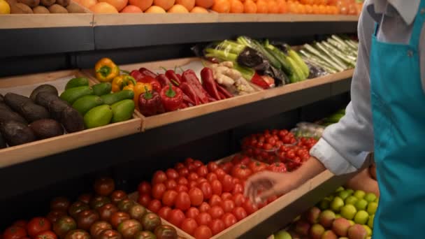 Empregado do supermercado colocando tomates na prateleira — Vídeo de Stock