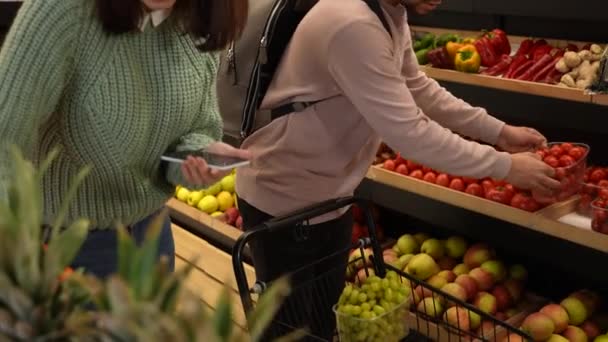 Молодая пара покупает продукты в продуктовом магазине — стоковое видео
