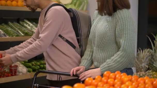 Aangenaam koppel kiezen tomaten in supermarkt — Stockvideo