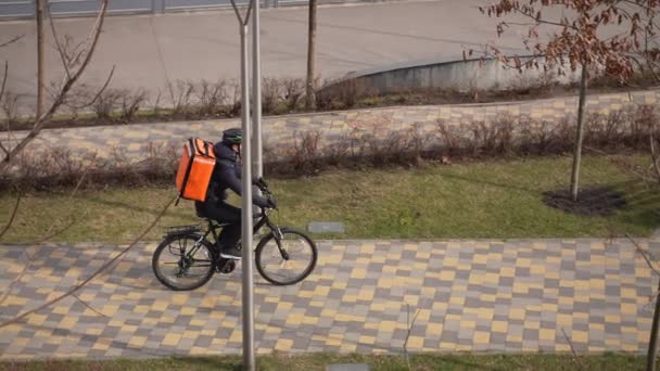 Bicicleta de equitação de correio mascarado entregando comida encomendada — Vídeo de Stock