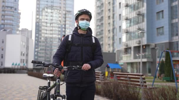 Entrega enmascarada mensajero de alimentos caminar bicicleta de transporte — Vídeo de stock