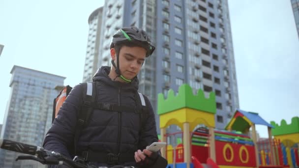 Deliveryman tomando pedido en línea en el teléfono al aire libre — Vídeos de Stock