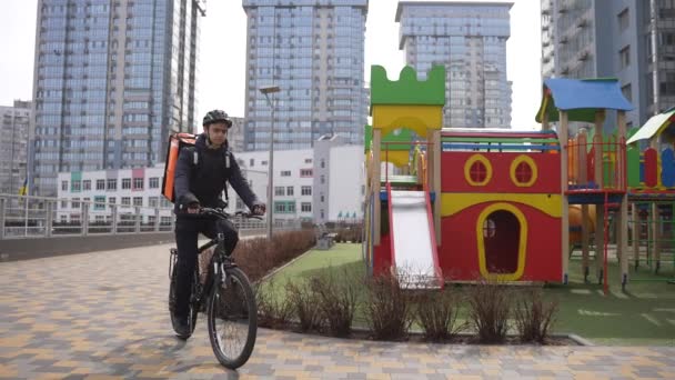 Entrega homem deixando bicicleta e caminhando para o edifício — Vídeo de Stock