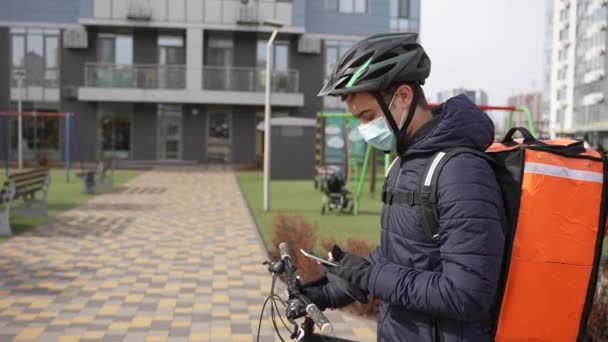 Maskovaný kurýr přebírá objednávku pomocí telefonu — Stock video