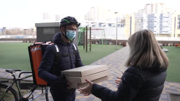 Correio de alimentos entregando pizza ao cliente de bicicleta — Vídeo de Stock