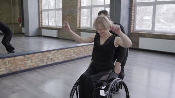 Веселая пара танцоров во время катания на инвалидных колясках — стоковое видео