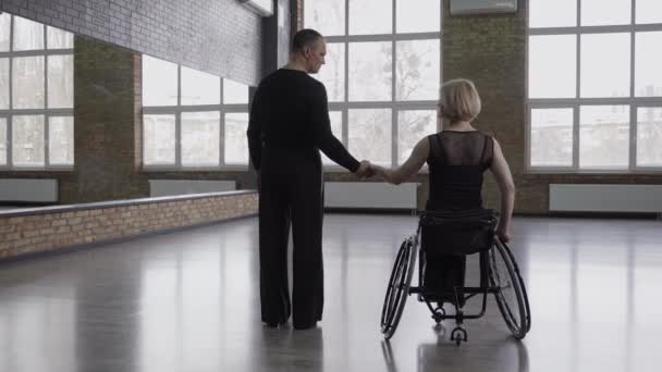 Пара танцоров держатся за руки в бальном зале — стоковое видео