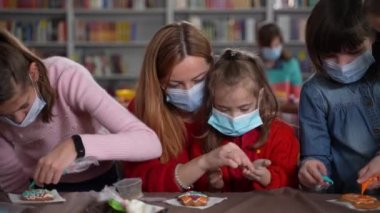 Maskeli öğretmen ve otistik kız kurabiye dekorasyonu