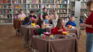 Özel ihtiyaçları olan çocuklar öğretmenlerine bakıyor.