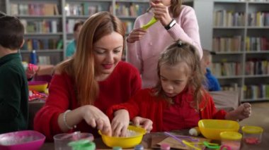 Engelli çocuklarla balçık yapan kadın öğretmen.