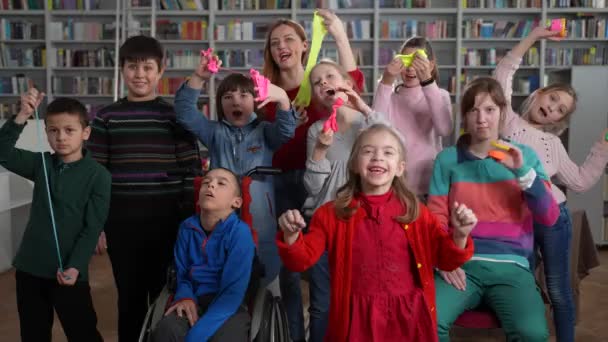 Fröhliche Kinder mit besonderen Bedürfnissen posieren im Unterricht — Stockvideo