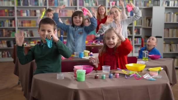 Счастливые дети с ограниченными возможностями машут руками в классе — стоковое видео