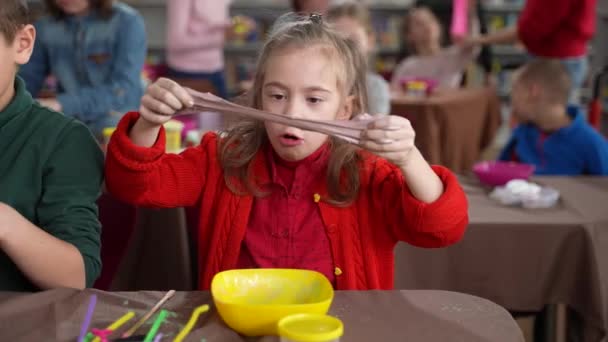 Menina autista bonito alongamento lodo em masterclass — Vídeo de Stock