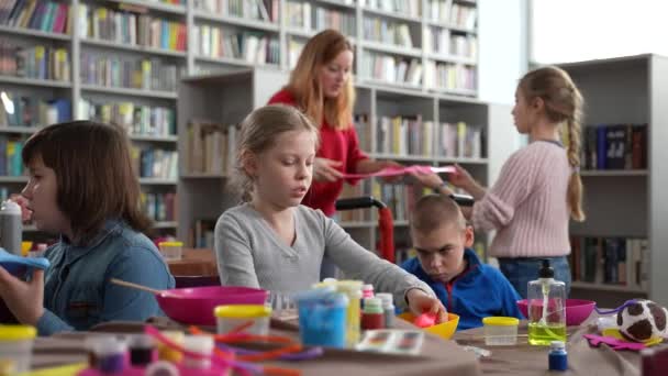 Kinder mit besonderen Bedürfnissen spielen in Bibliothek Schleim — Stockvideo