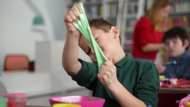 Mignon autiste garçon jouer slime à maître classe — Video