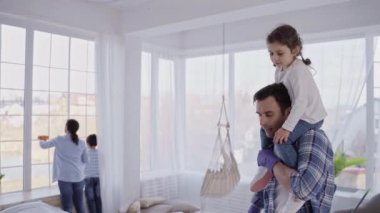 Adam omuzlarında kızıyla yerleri yıkıyor.