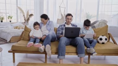 Çocuklu modern bir aile evde alet kullanıyor.