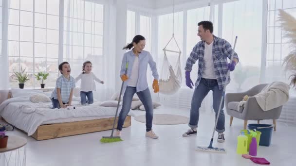 Casal alegre se divertindo durante a limpeza da casa — Vídeo de Stock