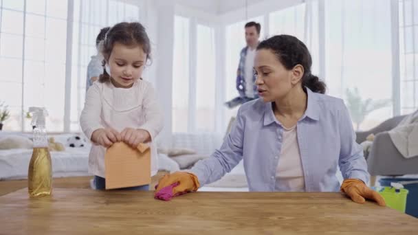 Madre cariñosa enseñando a su hija a desempolvar en casa — Vídeos de Stock