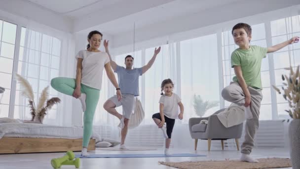 Crianças treinando para manter o equilíbrio na pose de ioga — Vídeo de Stock