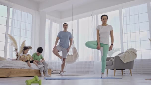 健康夫妇在家训练树瑜伽姿势 — 图库视频影像