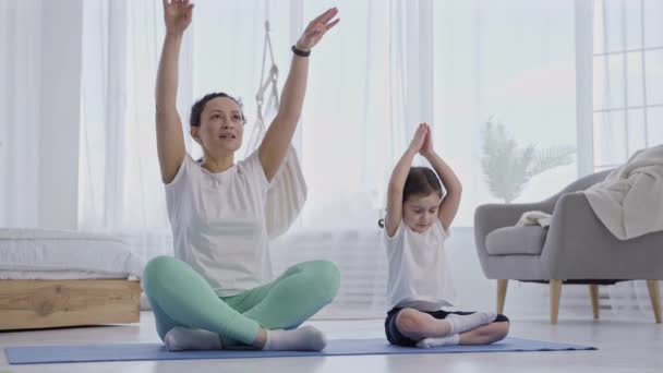 Mère enseignant fille à faire des exercices de yoga ensemble — Video