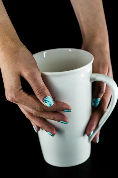 Руки с красивыми ногтями держа чашку — стоковое фото