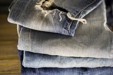 ahşap bir arka plan üzerinde katlanmış farklı kot pantolon