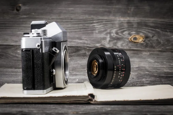 Old camera at  vintage book, wooden background — Stock Photo, Image