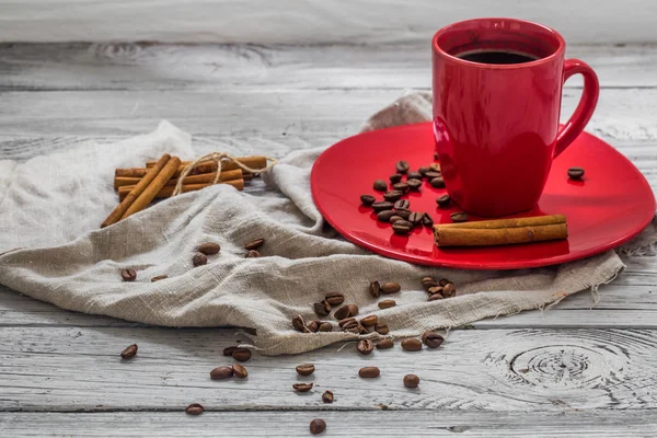 Copo de café vermelho em um prato, fundo de madeira, bebida, manhã de Natal — Fotografia de Stock
