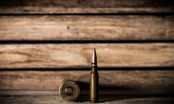 Weapons, cartridge on wooden background — Stock Photo, Image