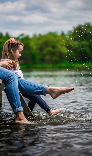 Mutter mit kleinem Mädchen auf Holzsteg und nassen Füßen — Stockfoto