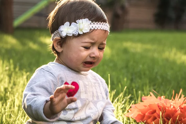 Эмоции маленькая девочка, на фоне зеленой травы — стоковое фото