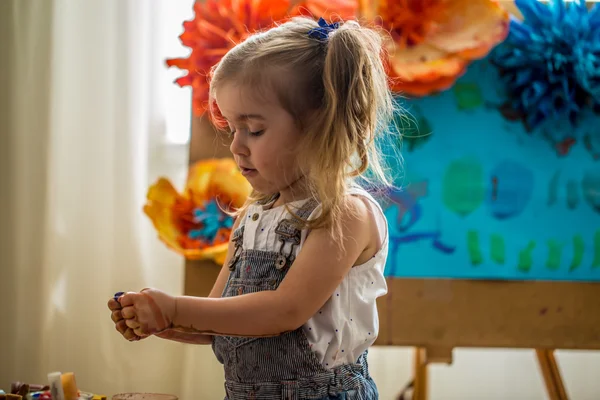La niña en el proceso de pintura, en el caballete — Foto de Stock