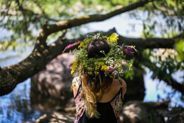 bir çelenk kız güzel kıyısında çiçekler nehir, güneşli bir gün.