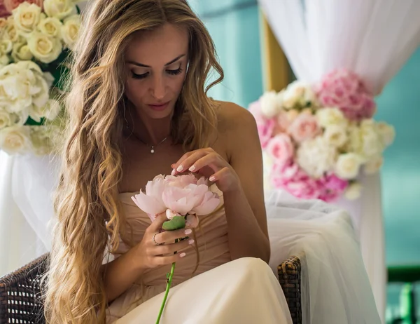 Hermosa joven con flores de pelo largo en la mano —  Fotos de Stock