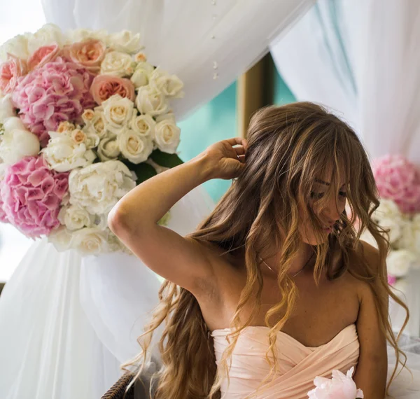 Hermosa joven con flores de pelo largo en la mano —  Fotos de Stock