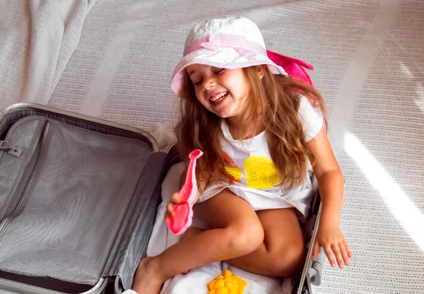Krásná holčička, sedící v kufru s hračky batoh na ramenou — Stock fotografie